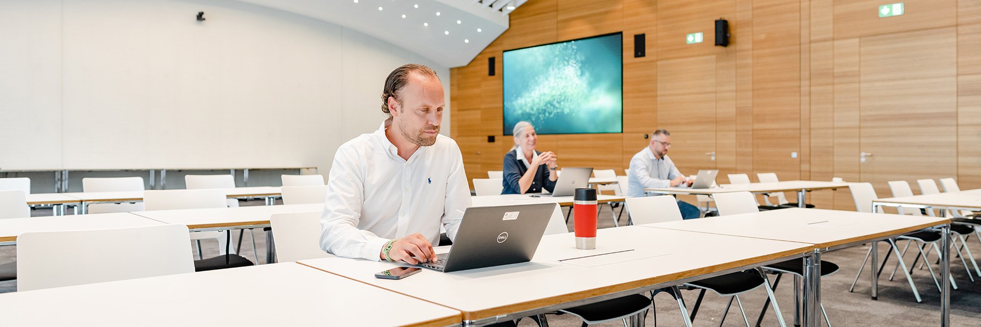 Three people sitting in a conference room